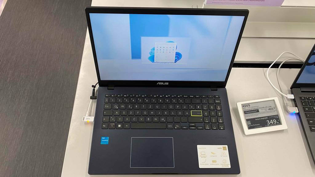 Günstiger-Laptop im Test: eingeschalteter Laptop, mit Preisschild (349,-) daneben, steht als Ausstellungsstück in einem Geschäft.