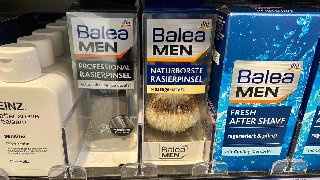 Zwei getestete, verpackte Rasierpinsel stehen nebeneinander im Regal.