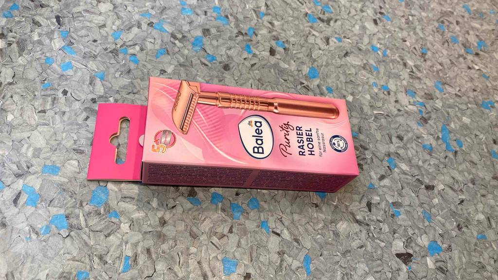 Rasierhobel für Frauen getestet: Eine Packung liegt horizontal auf einem grauen Boden.