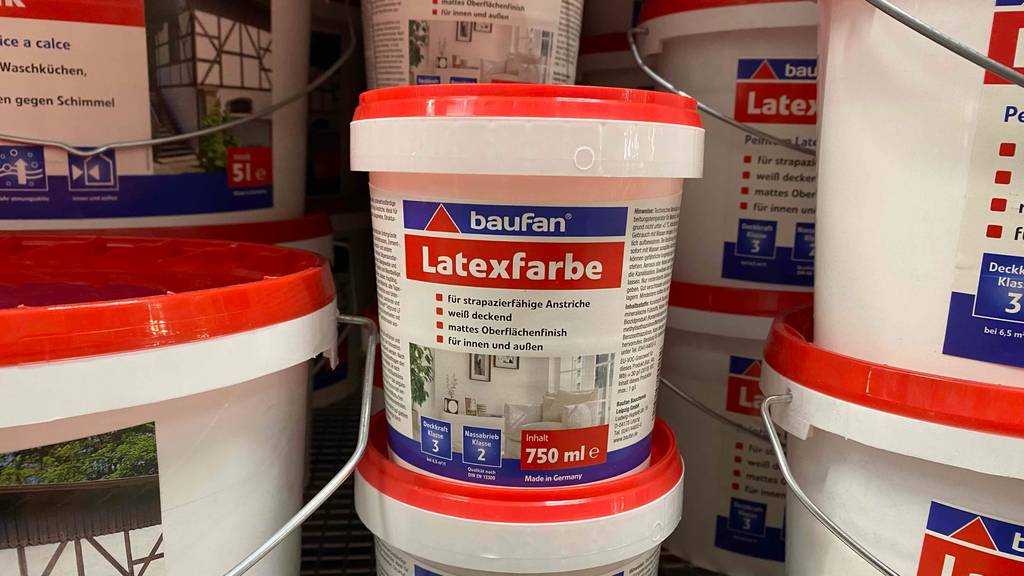 Im Test: Mehrere Eimer der Latexfarbe stehen übereinander und nebeneinander im Regal.