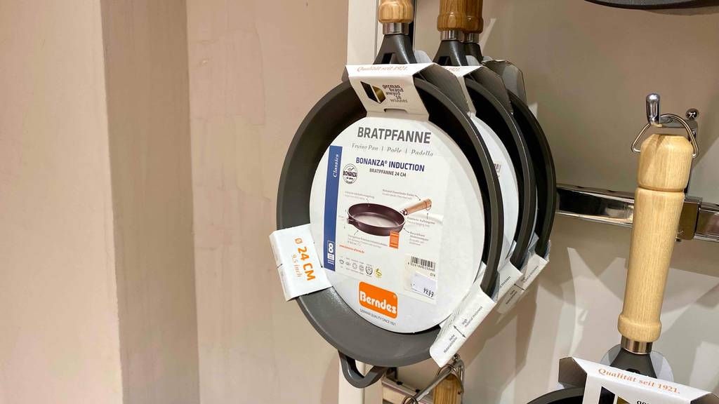Berndes-Pfanne im Test: mehrere Berndes-Pfanne mit einem Durchmesser von 24 cm hängen in einem Regal.