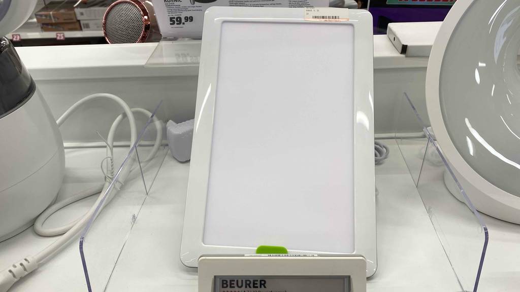 Eine getestete Beurer-Tageslichtlampe in einer Halterung auf einer hellen Fläche.