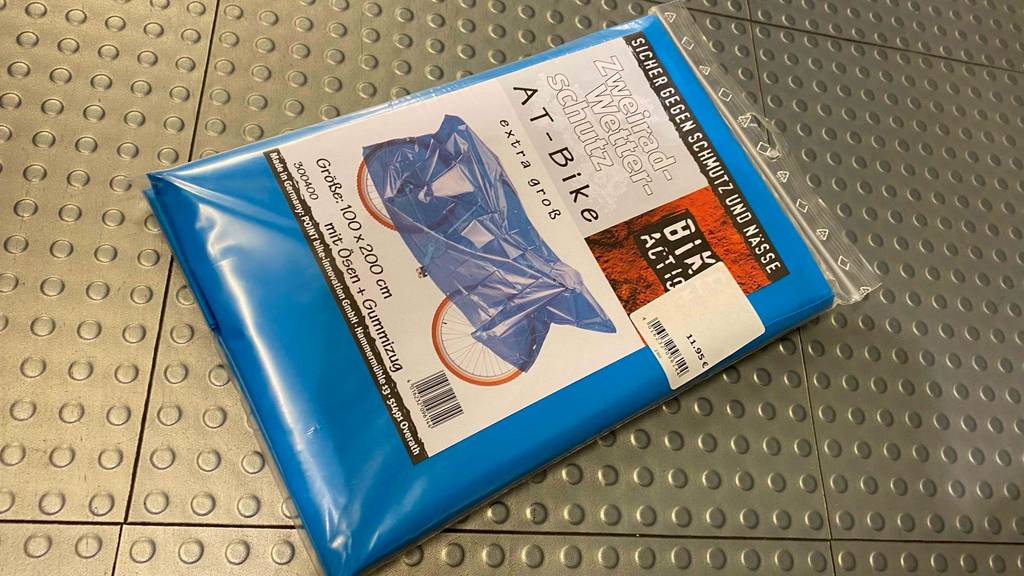 Fahrradschutzhülle getestet: blaue Fahrradschutzhülle in Verpackung liegend mit Preisschild darauf.