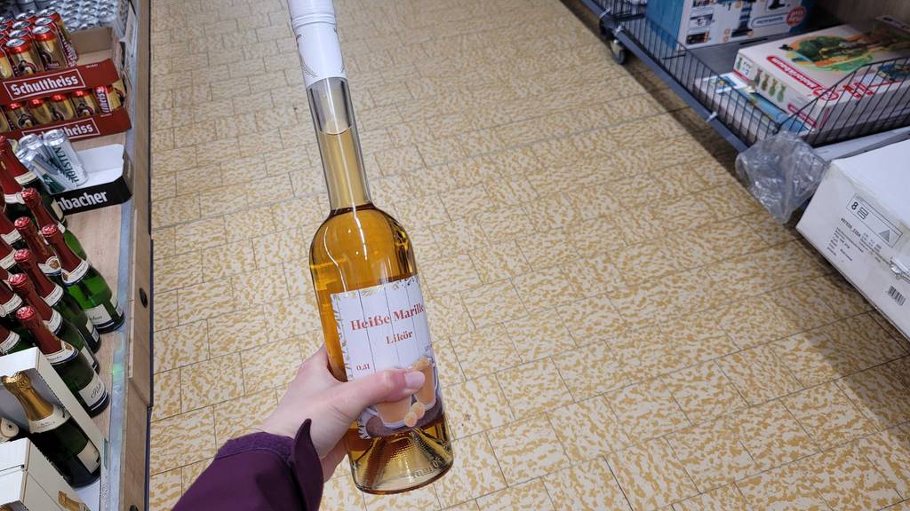 Der getestete Marillenlikör wird in einem Geschäft in der Hand gehalten.