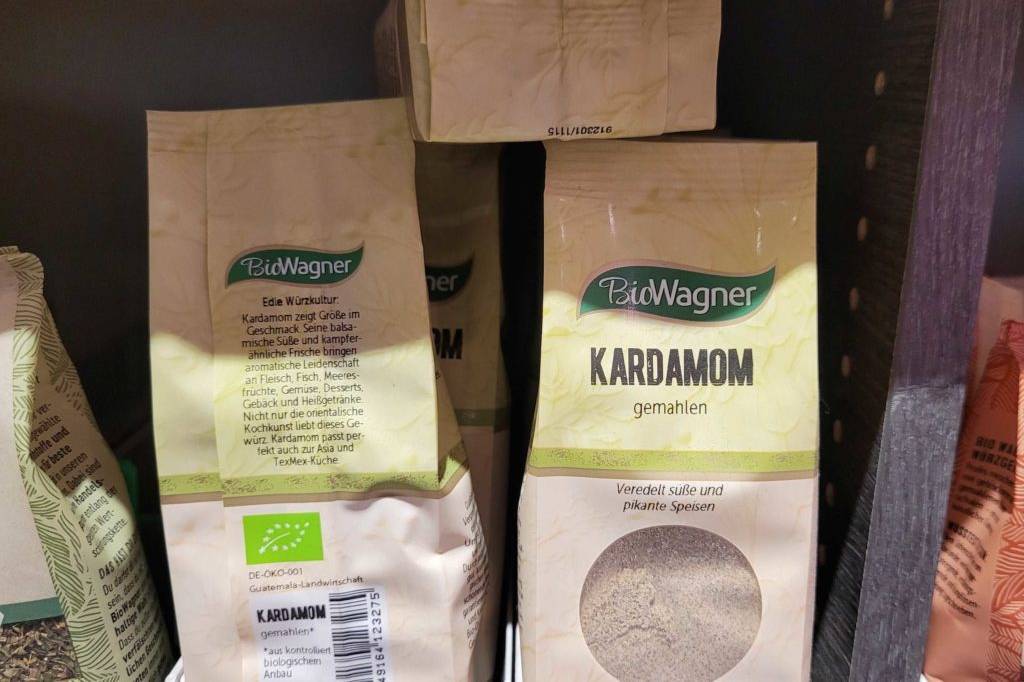 Kardamom im Test: Kardamom Packungen in Regal stehend Rückseite und Vorderseite von Verpackungen zu sehen.