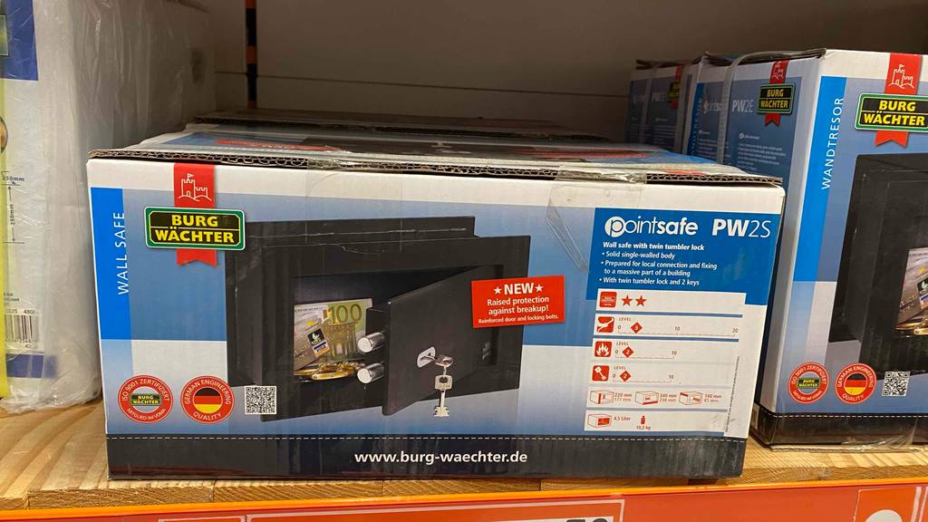 Wandtresor im Test: Verpackung von Wandtresore der Marke Burg Wächter stehen in einem Regal.