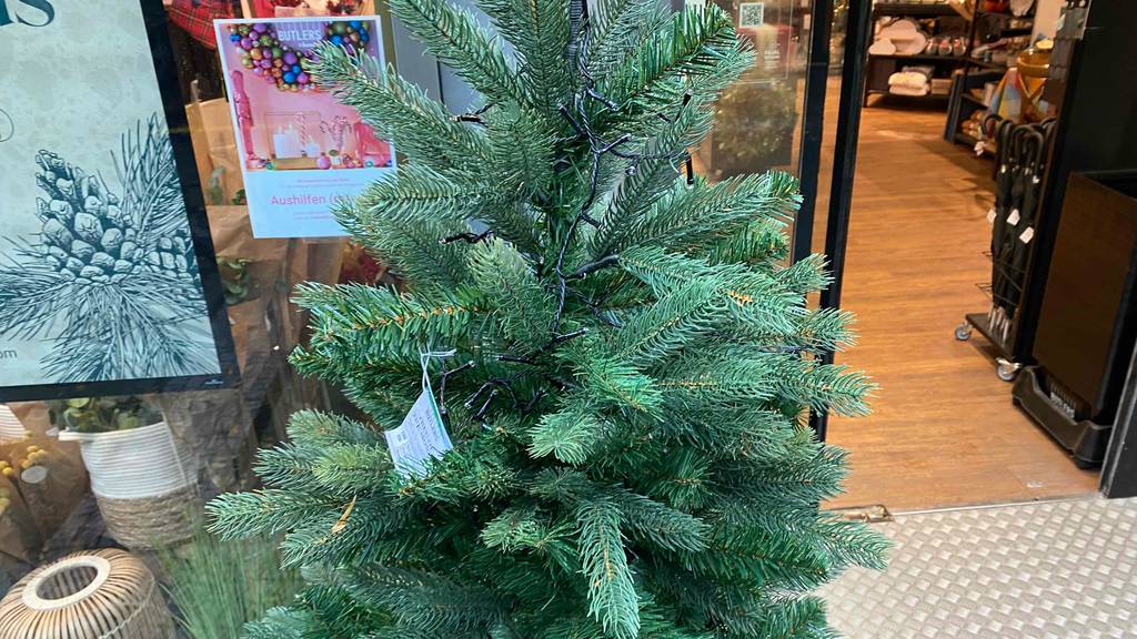 Weihnachtsbaum-Test: grüner Weihnachtsbaum steht vor einem Geschäft.