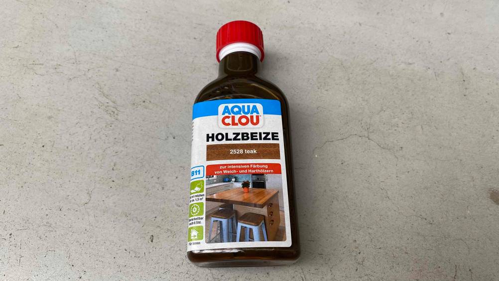 Holzbeize getestet: Eine Flasche liegt auf einem Steinboden