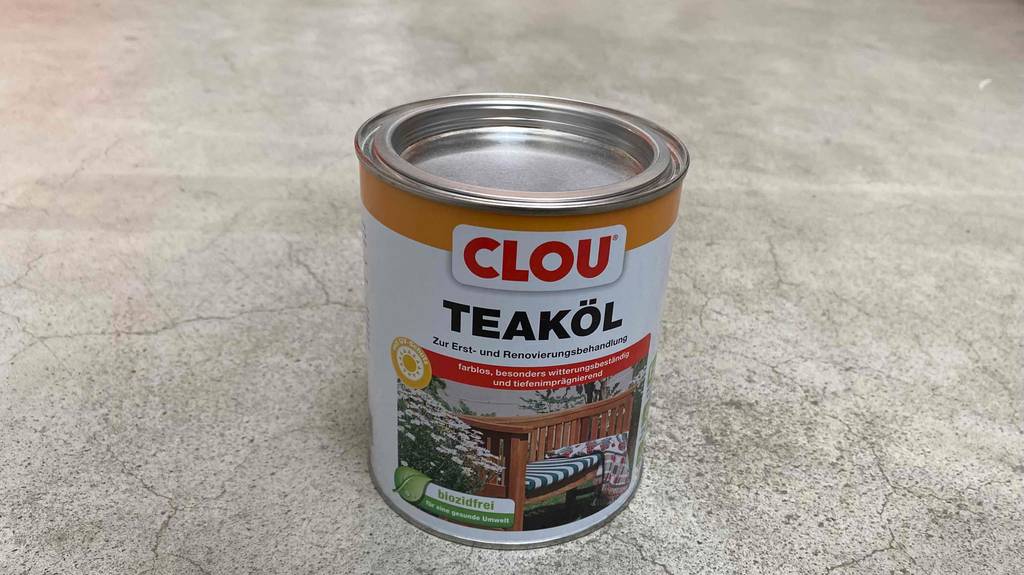 Teaköl im Test: Verschlossene Dose Teaköl auf einem Boden stehend mit Info zu Behandlungsmöglichkeiten.