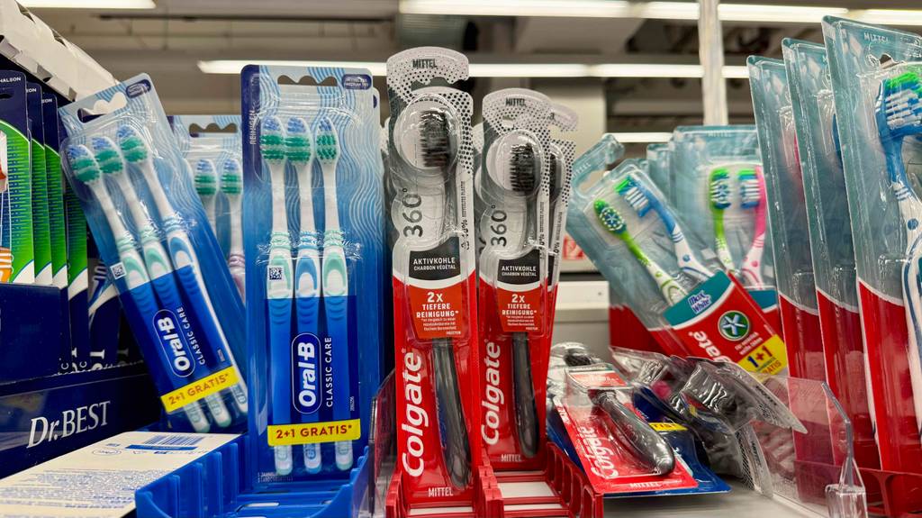 Aktivkohle-Zahnbürsten-Test: Mehrere Packungen von Colgate hängen an einem Verkaufsregal.