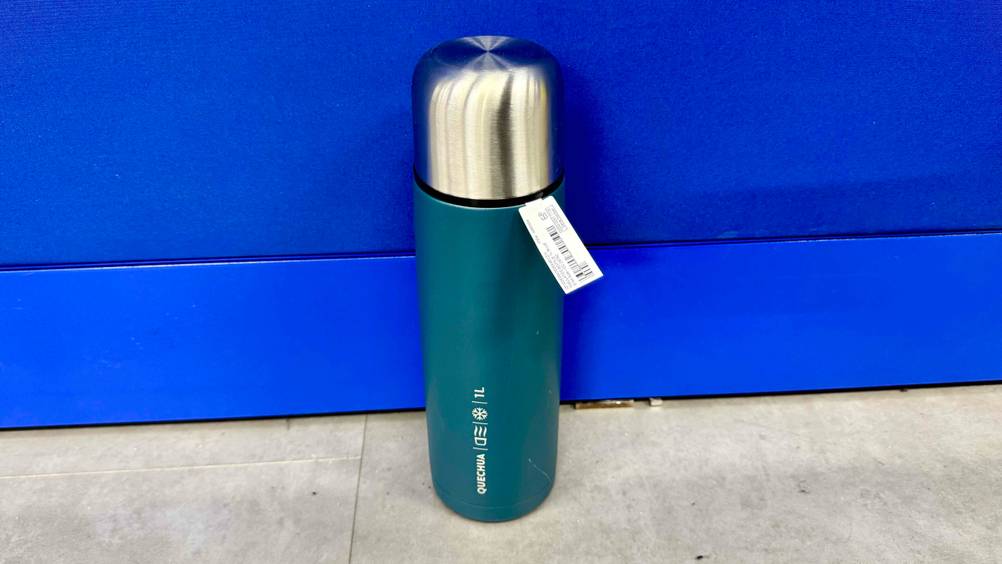 Die getestete Isolierflasche-1-Liter steht vor einer blauen Wand.
