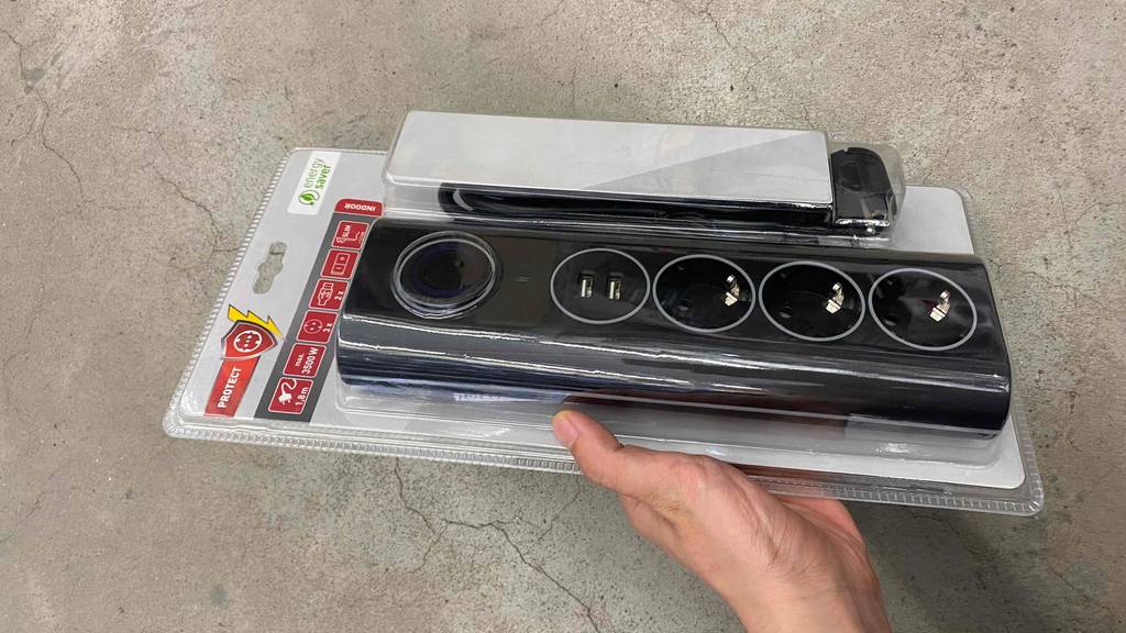 Getestete USB-Steckdose wird mit der Verpackung in einer Hand gehalten