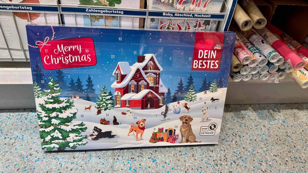 Der getestete Hunde-Adventskalender ohne Getreide ist an einem Regal angelehnt.