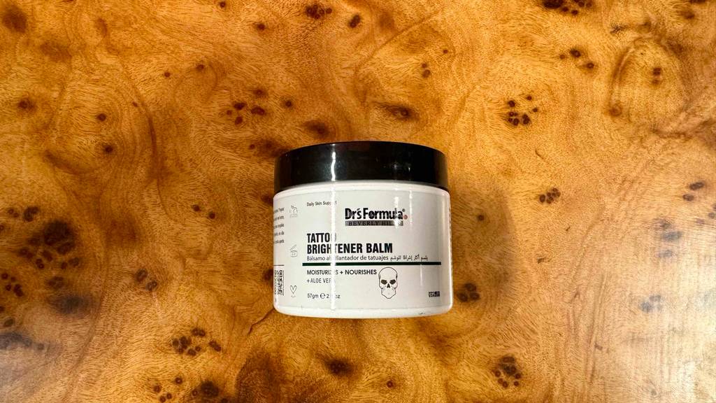 Die Vorderseite der getesteten Tattoo-Creme, die auf einer Holzfläche liegt.