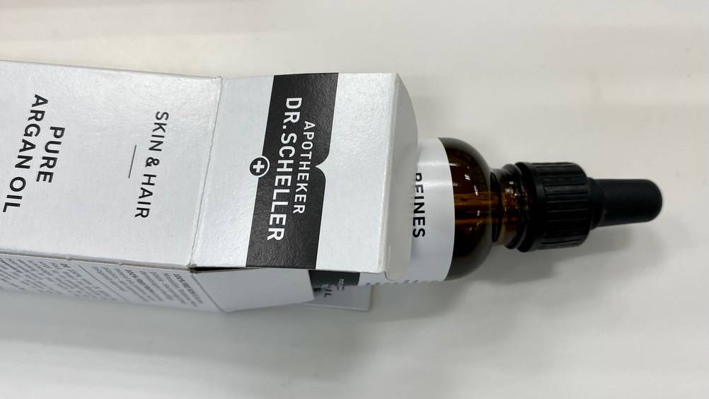 Aus einer geöffneten Packung schaut eine Flasche des getesteten Arganöls hervor.
