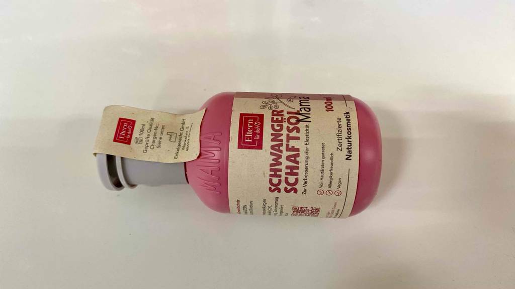 Schwangerschaftsöle im Test: eine Flasche Schwangerschaftsöl von zertifizierter Naturkosmetik mit 100 ml Inhalt horizontal auf einer weißen Fläche liegend.