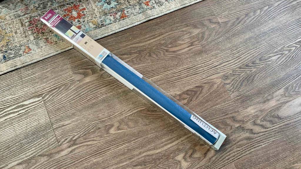 Eine getestete Thermo-Rollo liegt auf einem Holzboden.