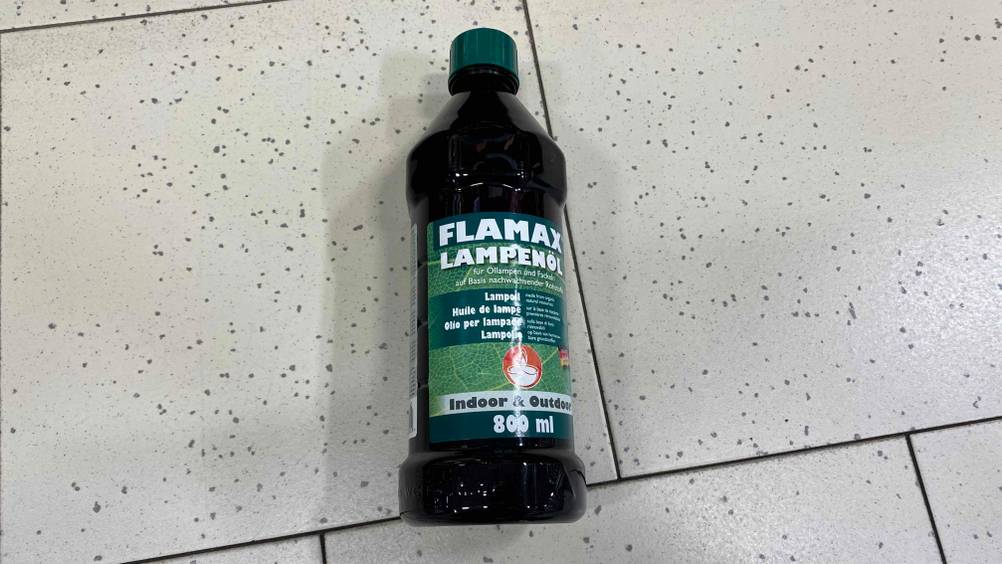 Lampenöl getestet: Lampenöl in getönter Flasche mit 800 ml Inhalt liegt auf einem Boden.