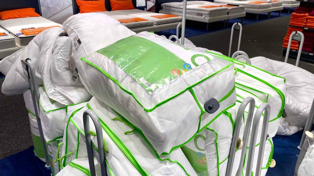 Microfaser-Bettdecke-Test: Meherere verpackte Decken auf einem Wagen.