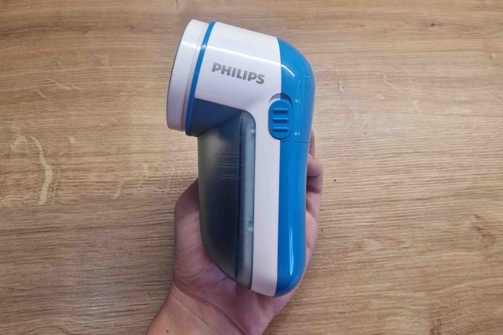 Fusselrasierer-Test: Fusselrasierer mit Fusseln in Auffangbehälter wird in der Hand gehalten.