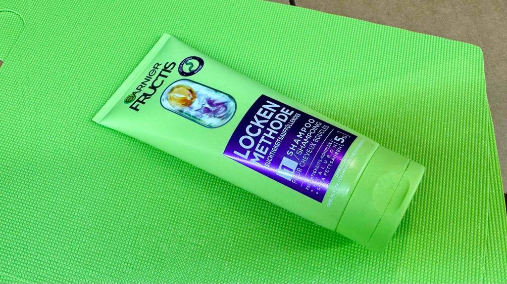 Test: Das liegende Locken-Shampoo, das sich auf einer grünen Matte befindet.