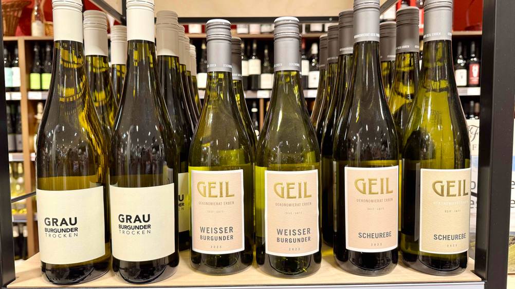 Mehrere Flaschen des getesteten Weißburgunders stehen in einem Regal.