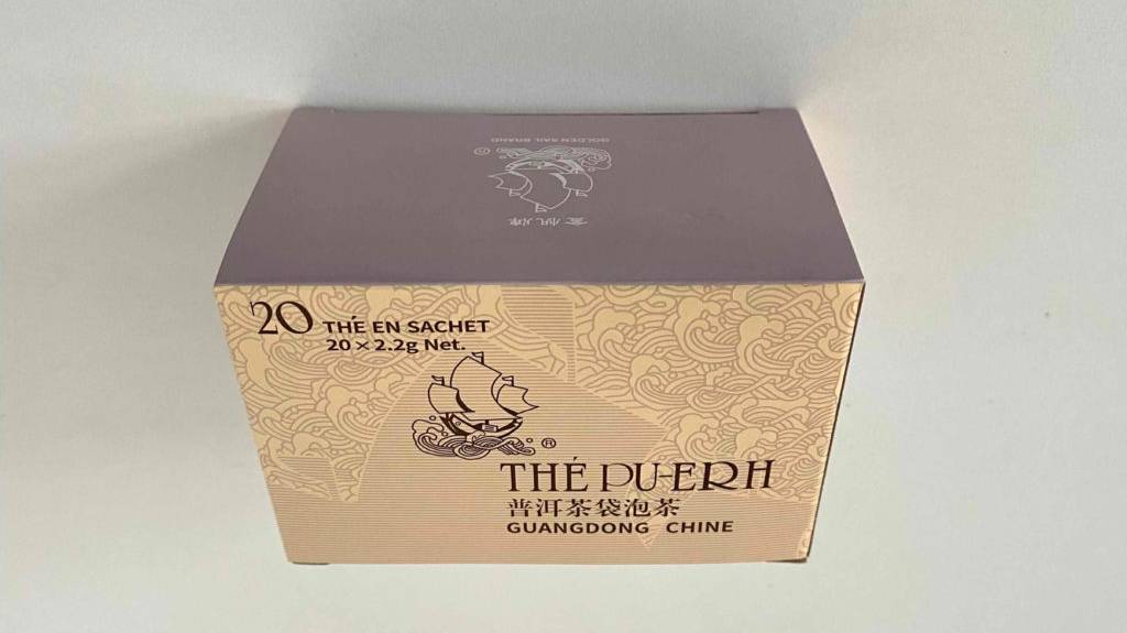 Pu-Erh-Tee im Test: Eine Packung Tee verkehrt herum auf einer weißen Oberfläche