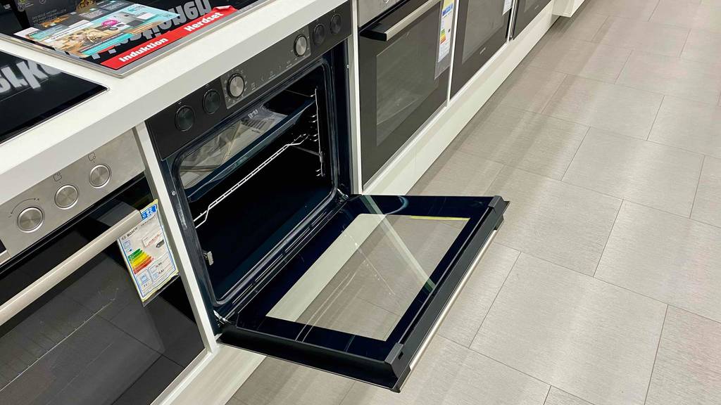Backofen-300-Grad im Test: ein Backofen mit geöffneter Türe steht neben anderen Modellen in einem Geschäft.