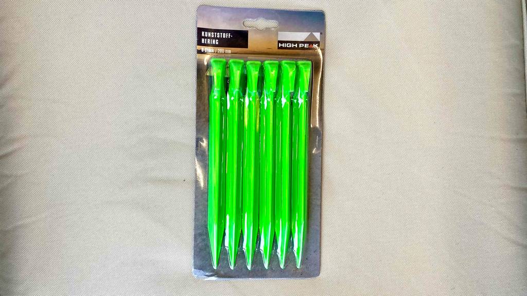 Zeltheringe getestet: Die Verpackung mit sechs grüne Zeltheringe darin liegt auf einem weißen Stoff.