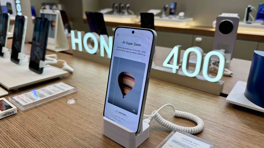 Das getestete Smartphone 6,5 Zoll wird in einem Geschäft neben anderen Modellen ausgestellt, wobei am Display das Kamera-Menü geöffnet ist.