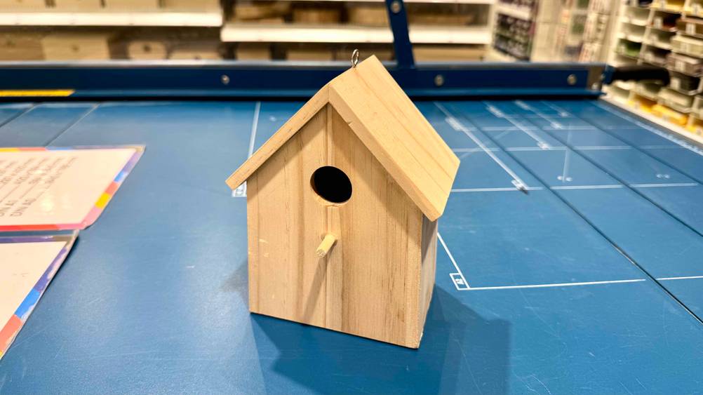 Das getestete Vogelhaus steht auf einer blauen Fläche in einem Geschäft.