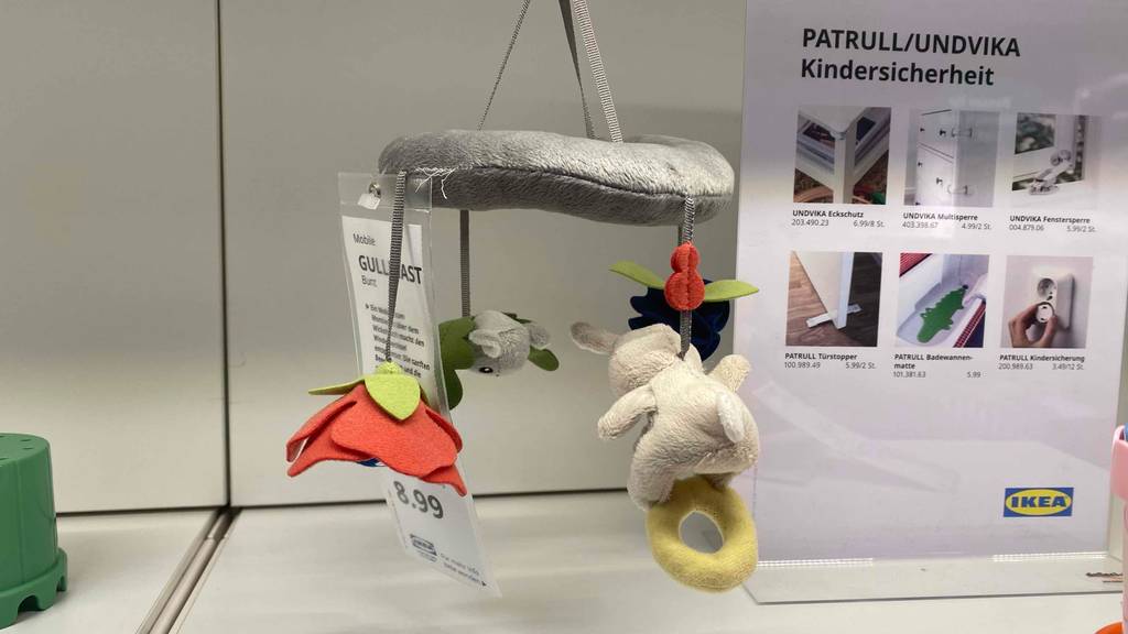 Baby-Mobile im Test: graues Baby-Mobile hängt als Ausstellungsstück neben anderem Kinderspielzeug.