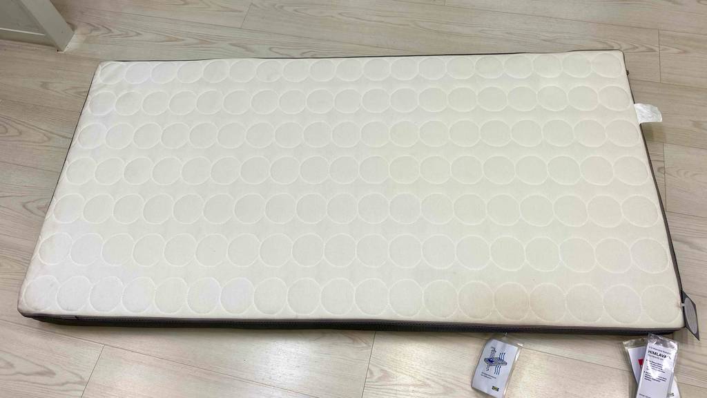 Kindermatratze-70x140 im Test: eine Kindermatratze liegend auf einem Boden von oben ersichtlich.
