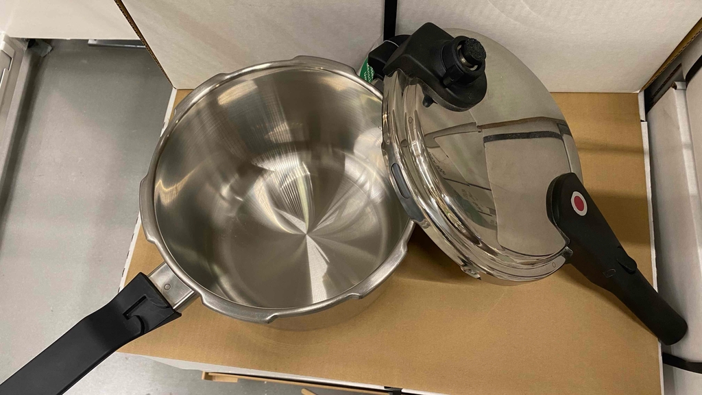 Schnellkochtopf im Test: Ein ausgepackter Schnellkochtopf mit Deckel steht auf einem Karton.