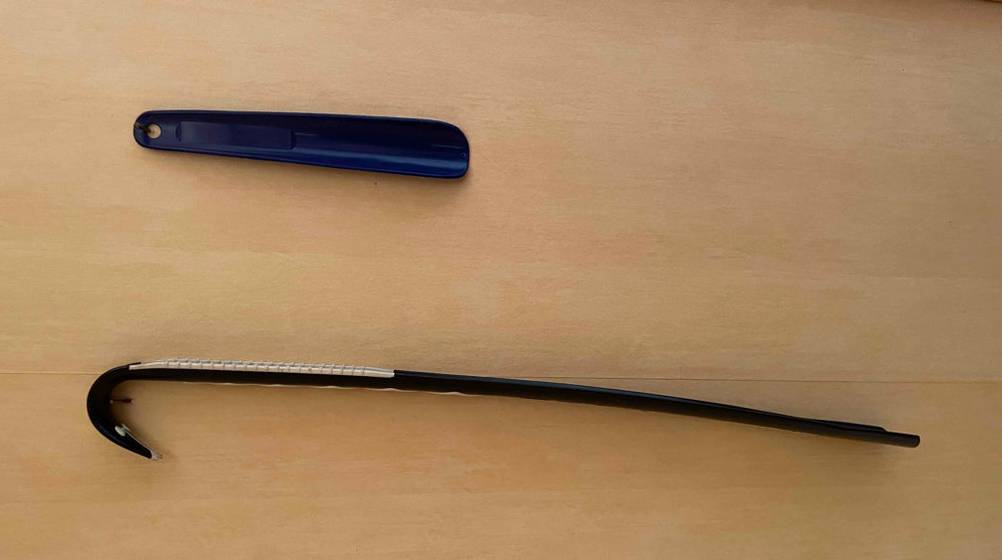 Schuhlöffel im Test: ein schwarzer Schuhlöffel von der Seite auf einem Boden liegend und daneben ein kleinerer Schuhlöffel platziert.