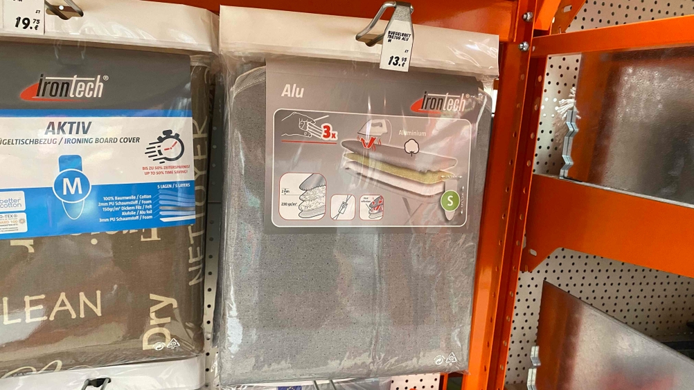 Im Test: Im Regal neben anderen Produkten hängt ein Bügelbrettbezug.