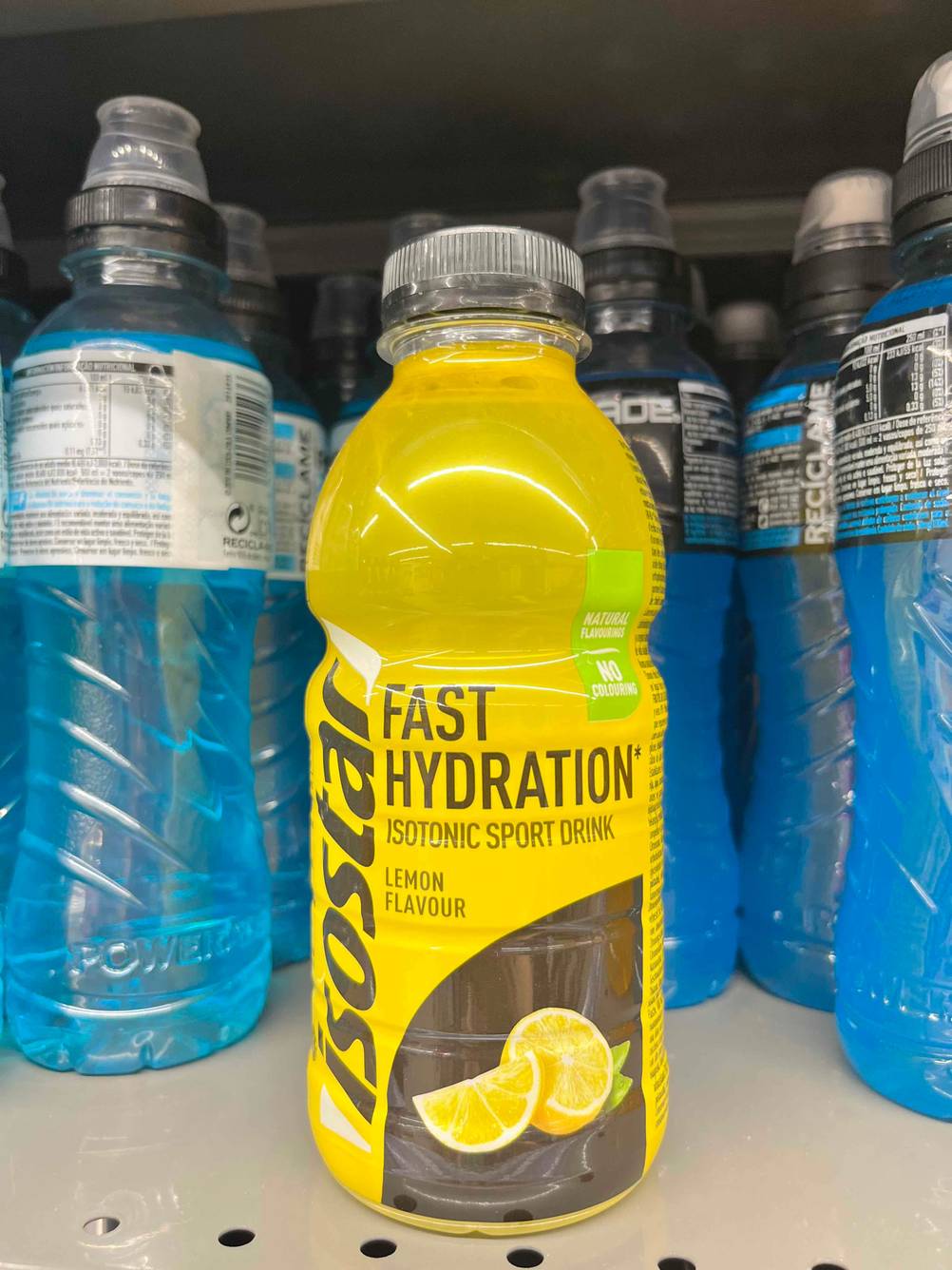 Isotonische Getränke im Test: Eine Flasche isotonisches Getränk steht mit der Vorderseite nach vorne in einem Getränkeregal