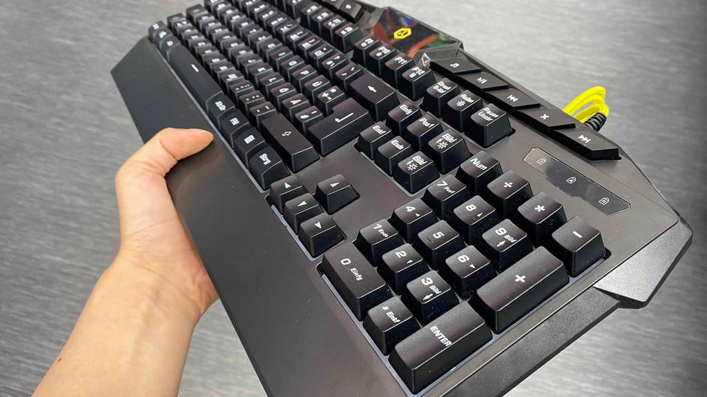 Gaming-Tastatur im Test: Tastatur wird mit Hand über grauem Tisch gehalten