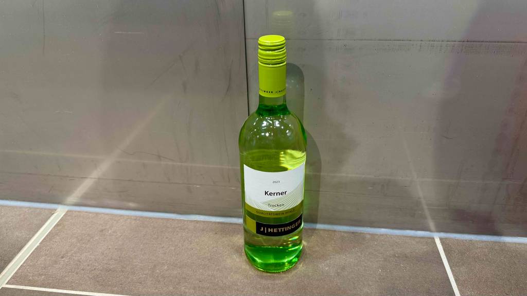 Eine Flasche getesteter Kerner-Wein steht vor einer Wand.