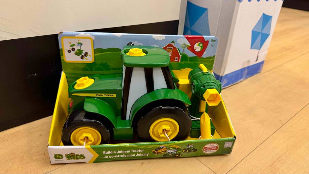 Ein Spielzeugtraktor der getestet wurde befinden sich noch in der Verpackung und ist auf einen Boden platziert.
