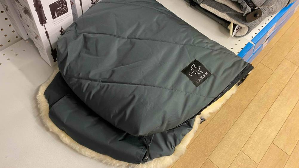 Im Test: Ein gefalteter Lammfell-Fußsack liegt neben anderen Produkten im Regal.