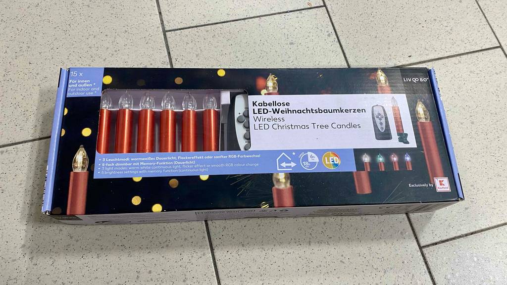 Im Test: Auf einem Fließenboden liegen verpackte kabellose Christbaumkerzen.