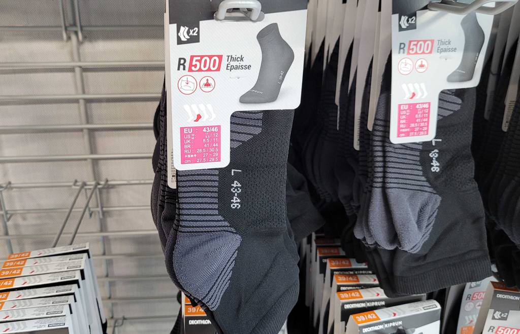 Frontansicht der getesteten Laufsocken, welche in einem Regal hängen.