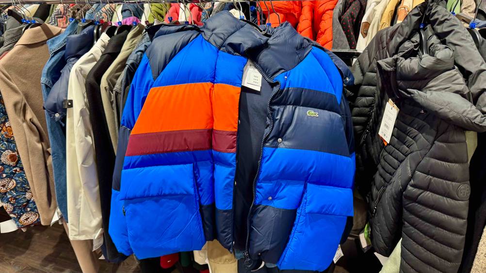 Eine Winterjacke von Lacoste, die getestet wurde, hängt auf einer Kleiderstange.