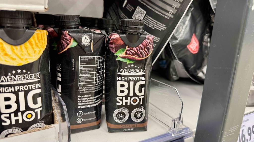 Mehrere Eiweißdrinks stehen in einem Regal.