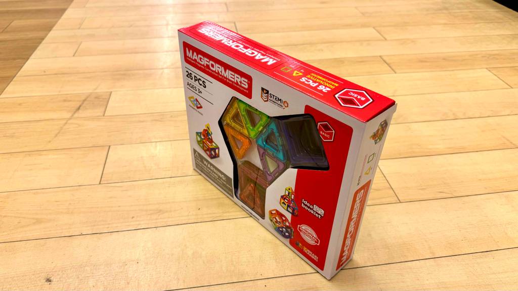 Eine aufrecht stehende, getestete Verpackung von magnetischen Bausteine ist auf einem Boden platziert.