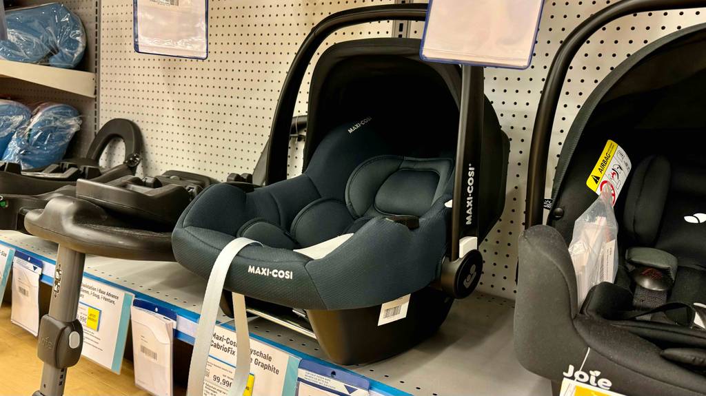 Eine getestete Maxi-Cosi-Babyschale ist in einem Regal platziert mit Preisschild ersichtlich.