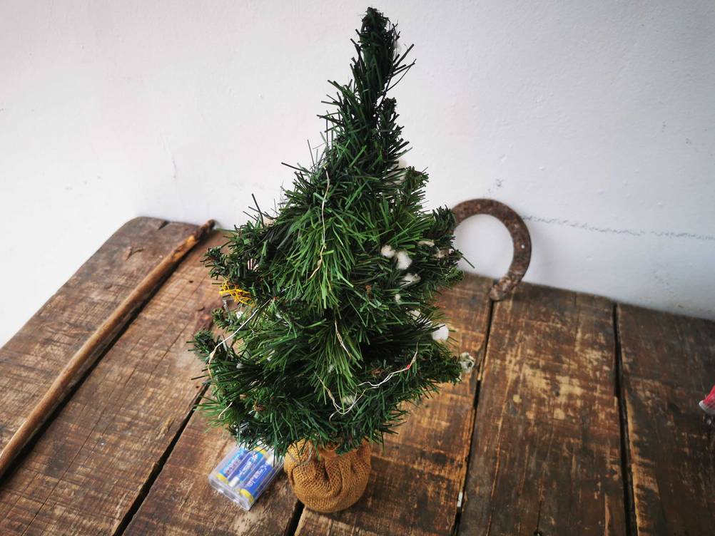 Der getestete Mini-Weihnachtsbaum steht auf einem Holztisch.