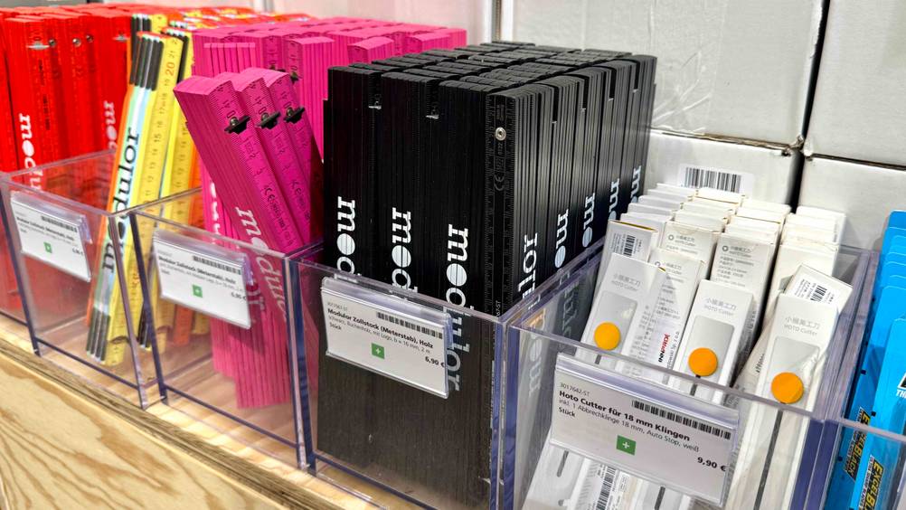 Mehrere Zollstöcke in verschiedenen Farben befinden sich in transparenten Kunststoffboxen.
