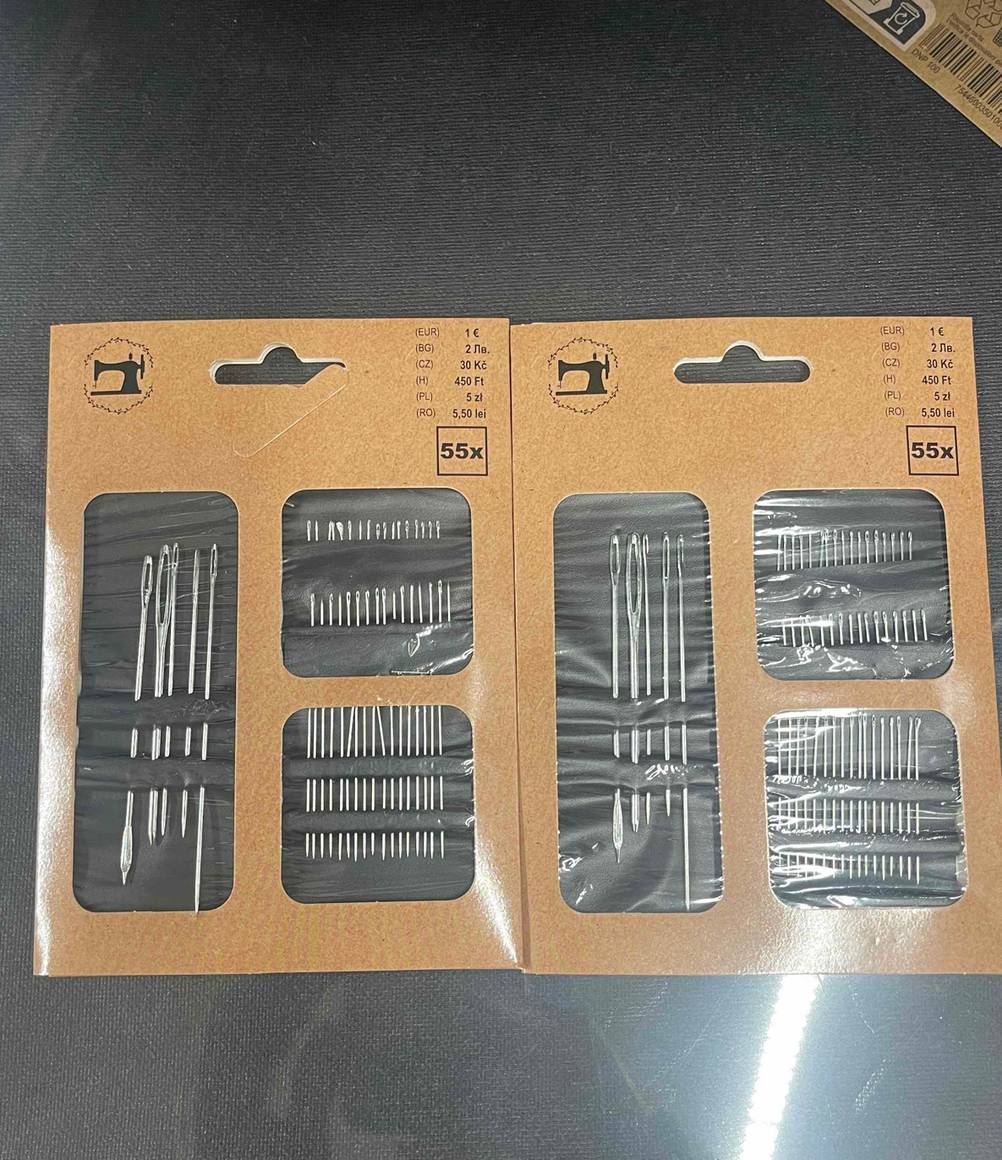 Zwei Packungen der getesteten Nähnadeln mit unterschiedlichen Größen liegen nebeneinander.